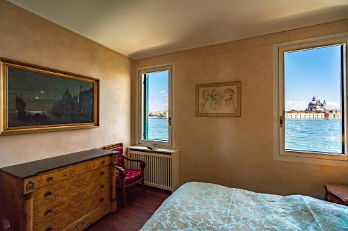 a bedroom with a bed and two windows at Apartment Dorotea Venice view in Venice