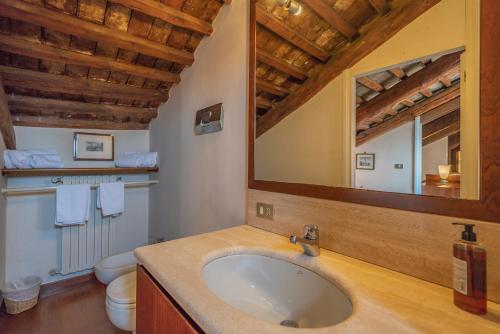 a bathroom with a sink and a mirror and a toilet at Giudecca Apartment in Venice