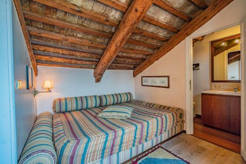 a bed in a bedroom with a wooden ceiling at Giudecca Apartment in Venice