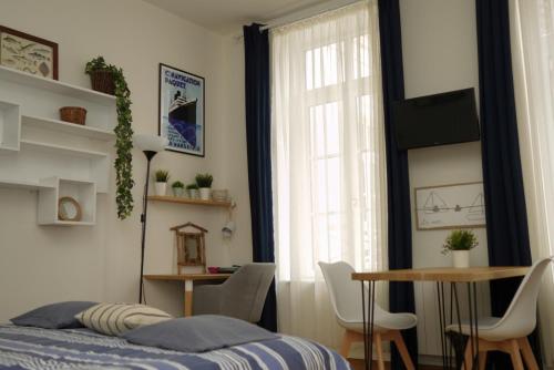 une chambre avec un lit, une table et une fenêtre dans l'établissement Studio cosy idéalement situé et bien équipé, à Boulogne-sur-Mer