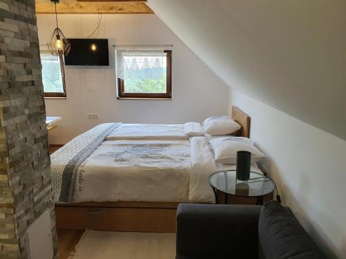 a bedroom with a bed and a couch and a window at Relaxing Cottage Donacka Gora in Rogatec