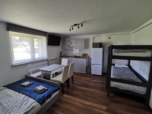 a dorm room with a bed and a table and a kitchen at Pokoje pod Baranami Zator Przeciszów in Przeciszów