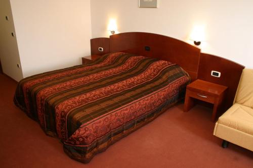 une chambre d'hôtel avec un lit et une chaise dans l'établissement Hotel Krek Superior, à Lesce