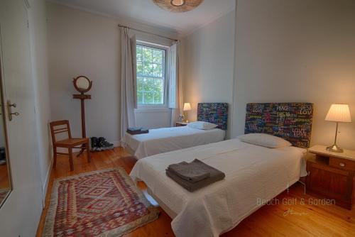 ein Schlafzimmer mit zwei Betten und einem Fenster in der Unterkunft Beach Golf & Garden House in Arcozelo