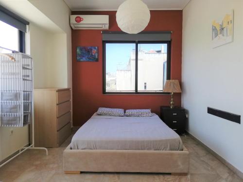 1 dormitorio con cama y ventana en 5th floor apartment with city view en Athens