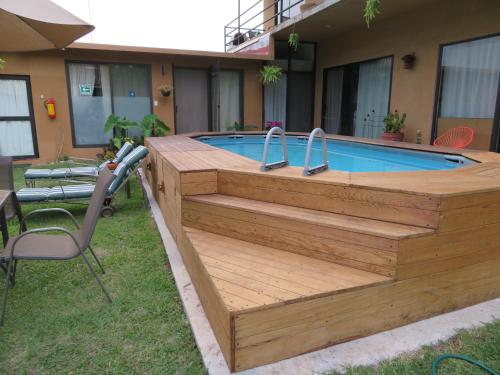 una piscina con terrazza in legno accanto a una casa di Posada Casa Topiltzin a Tepoztlán