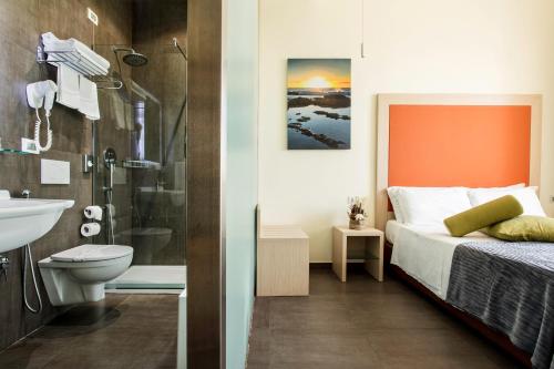 a bathroom with a bed and a toilet and a sink at Hotel 33 Baroni in Gallipoli