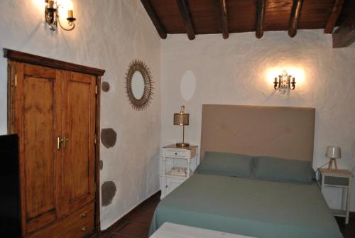 a bedroom with a green bed and a wooden door at RK La Casona de Tejeda in Tejeda