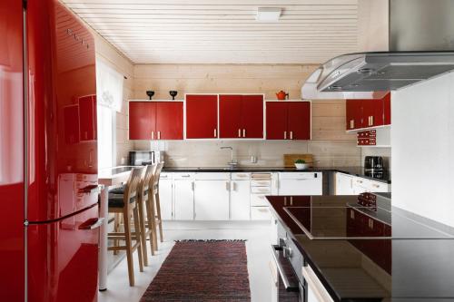 una cucina con mobili rossi e un piano di lavoro di Villa Kaikuranta a Nellimö