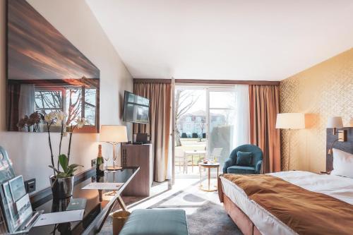 een hotelkamer met een bed en een bureau bij SCHLOSS Fleesensee in Göhren-Lebbin