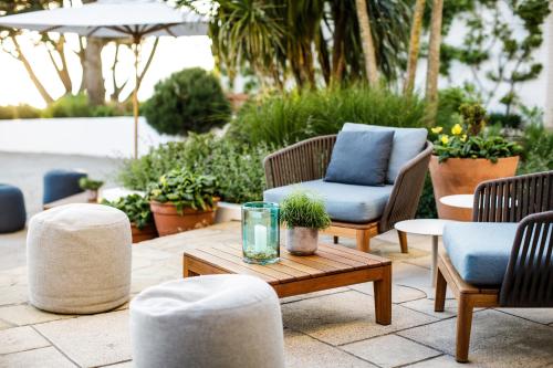 a patio with chairs and a wooden coffee table at The Atlantic Hotel - Small Luxury Hotels of the World in St Brelade