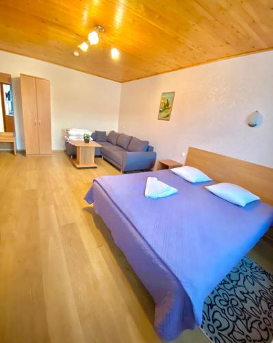 a bedroom with a large bed and a couch at Akmuo Ant Akmens in Šventoji