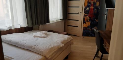 a small bedroom with a white bed and a window at Metropolis Apartamenty Centrum in Kalisz