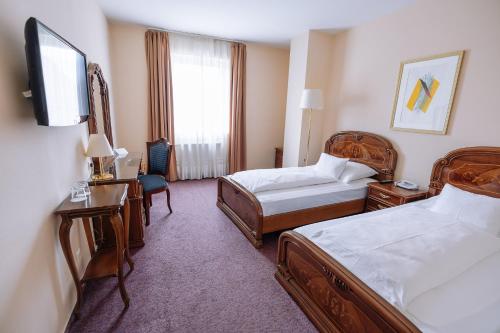 Кровать или кровати в номере Pannonia Hotel