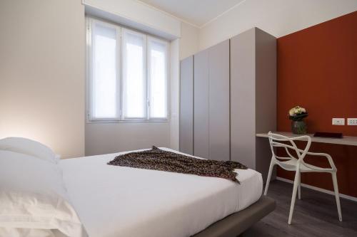 een slaapkamer met een bed, een bureau en een stoel bij Contempora Apartments - Cavallotti 13 - B14 in Milaan