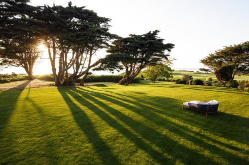 a field with trees and a couch in the grass at The Atlantic Hotel - Small Luxury Hotels of the World in St Brelade