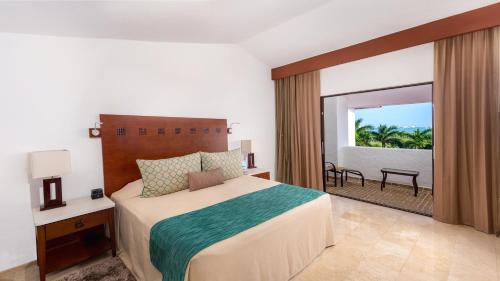 a bedroom with a bed and a view of the ocean at The Royal Cancun All Villas Resort in Cancún