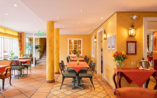 a dining room with tables and chairs in a restaurant at Strandhotel Sylt Westerland in Westerland (Sylt)
