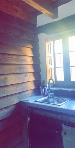 - une cuisine avec un évier et un mur en bois dans l'établissement La bergerie du Chêne, à Omessa