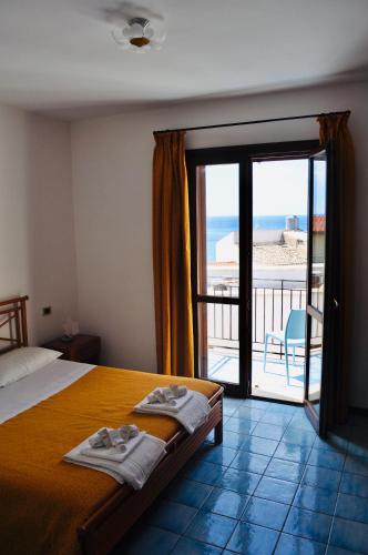 a bedroom with a bed and a view of the beach at Vivaldi Appartamenti in Marinella di Selinunte