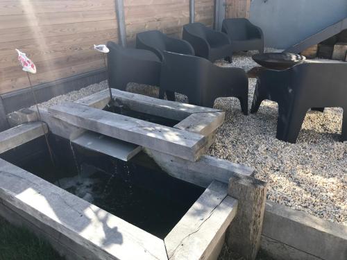 a fire pit with chairs and a grill at Etoile du Kap in Barneville-Carteret