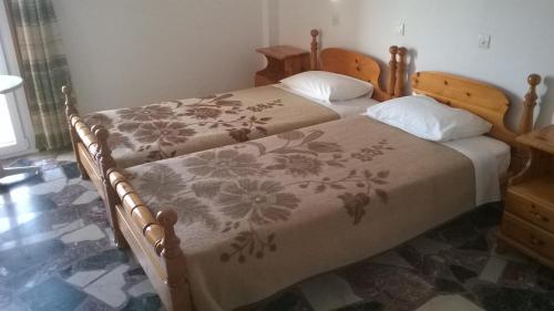 a bedroom with two twin beds with a floral bedspread at Lefteris Rooms in Kokkari