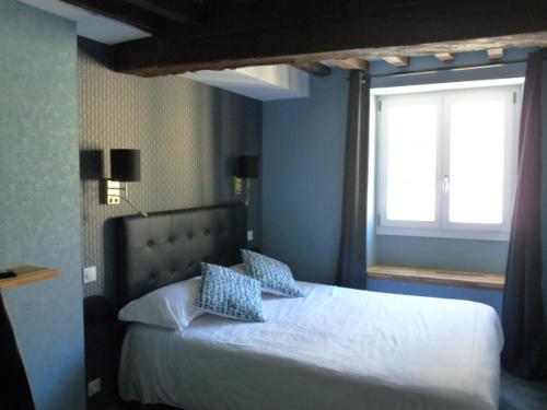 a bedroom with a white bed with a window at Le Port Malo in Saint Malo