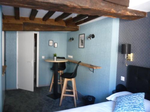- une chambre avec un lit et un tabouret dans l'établissement Le Port Malo, à Saint-Malo