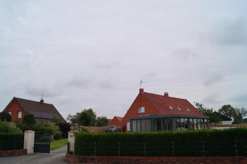 een huis met een rood dak in een tuin bij À La Maison Du Bonheur in Audruicq