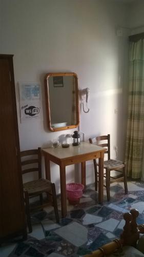 a dressing table with a mirror and two chairs at Lefteris Rooms in Kokkari