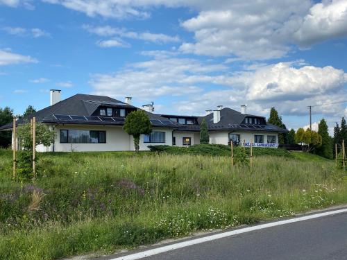 uma casa branca na berma de uma estrada em Zajazd Maj em Bolesław