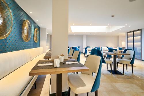 a dining room with tables and chairs and blue walls at Eurostars Astoria in Málaga