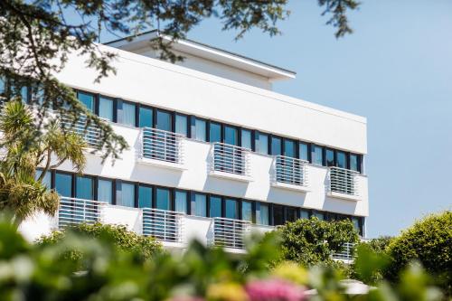 an office building with windows and trees at The Atlantic Hotel in St. Brelade