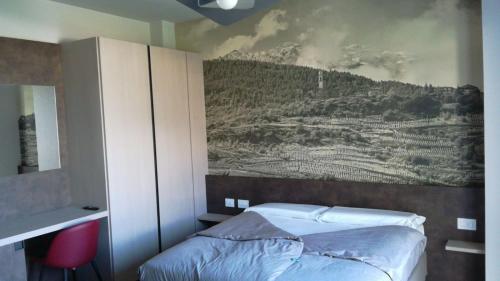 a bedroom with a painting on the wall above a bed at Locanda al Crap in Tresivio