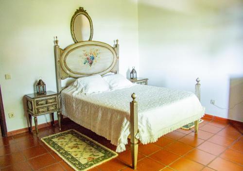 a bedroom with a bed and a mirror on the wall at Casa da Quinta do Outeiro in Viana do Castelo
