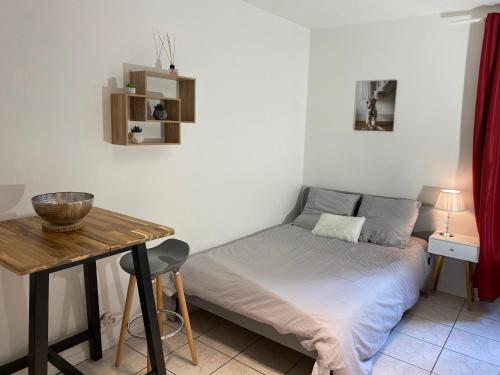 une petite chambre avec un lit et une table dans l'établissement Le 6T Gastro, à Dijon