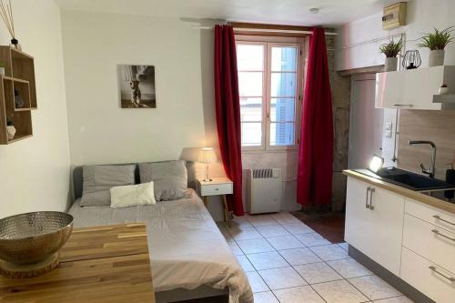 Cette chambre comprend un lit et une cuisine avec des rideaux rouges. dans l'établissement Le 6T Gastro, à Dijon