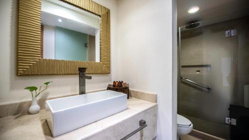 een badkamer met een witte wastafel en een spiegel bij Park Royal Beach Huatulco - All Inclusive in Santa Cruz Huatulco