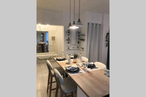 a dining room with a wooden table and chairs at Gare - Les Champs - 1 SDB privative - parking gratuit in Saint-Brieuc