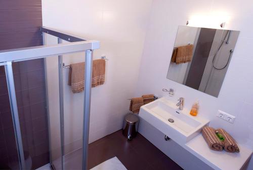 ein weißes Bad mit einem Waschbecken und einer Dusche in der Unterkunft Lux Alpinae in Nauders