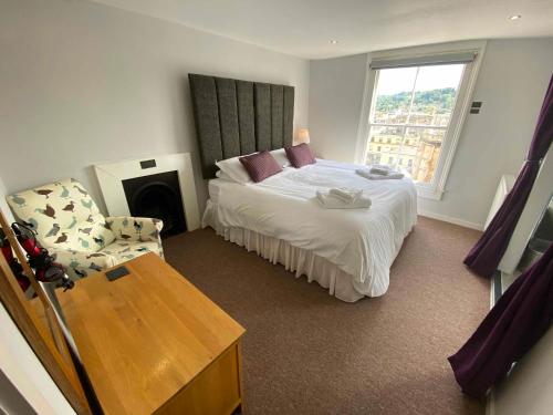 a bedroom with a bed and a chair in it at Bath Roof Terrace Apartment, City Centre, Sleeps up to 8 in Bath