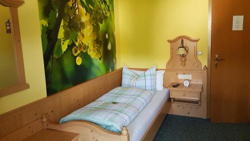 Una cama pequeña en una habitación con una pintura en Brunnenhof, en Bruttig-Fankel