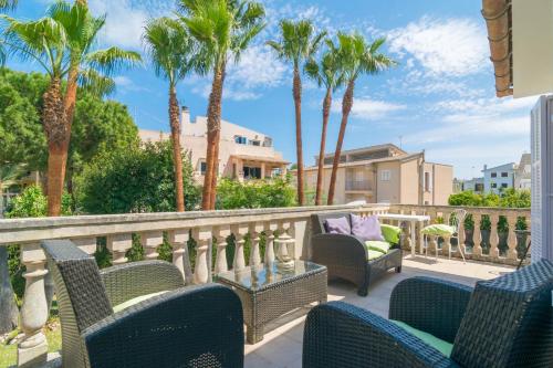 a balcony with chairs and palm trees at Anima in Can Picafort