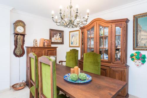 a dining room with a wooden table and green chairs at Anima in Can Picafort