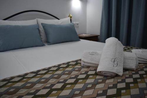 a bedroom with a bed with towels on it at Athena's Apartments & Studios in Sykia Chalkidikis