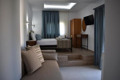 a hotel room with a couch and a bed at Athena's Apartments & Studios in Sykia Chalkidikis