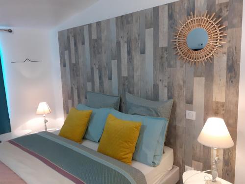Schlafzimmer mit einem Bett mit blauen und gelben Kissen in der Unterkunft Escale en baie. in Pontaubault