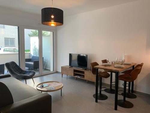 un salon avec un canapé, une table et une télévision dans l'établissement BLUE LAKE, à Annecy