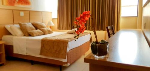 um quarto de hotel com uma cama grande e uma mesa em Hotel Nacional Inn São Carlos & Convenções em São Carlos