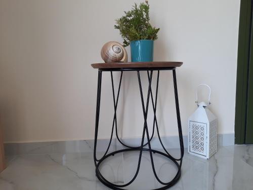 a side table with a plant and a bottle on the floor at Freesia Grand Sea View Residence in Sarlata